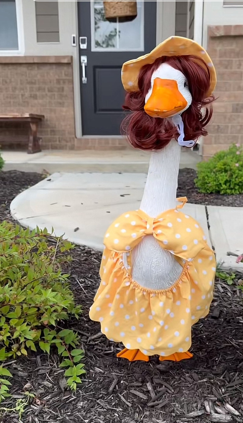 Lucy Goosey the porch goose in a yellow polka dot dress and matching bonnet